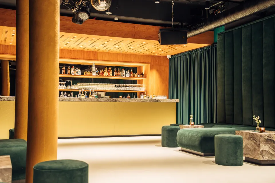 OSCHO: bar with yellow column, marble counter and green velvet curtains