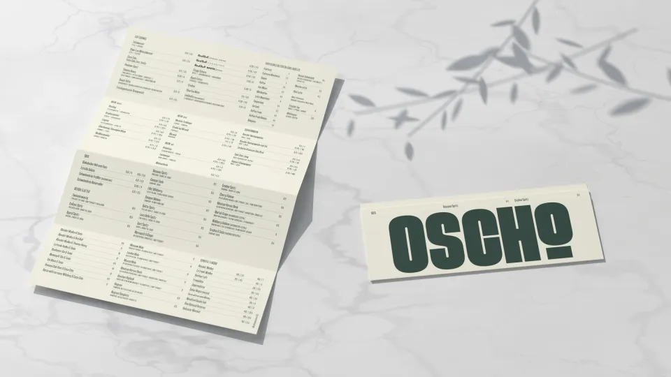 OSCHO: unfolded drinks menu and the menu sleeve with the large wordmark on marble