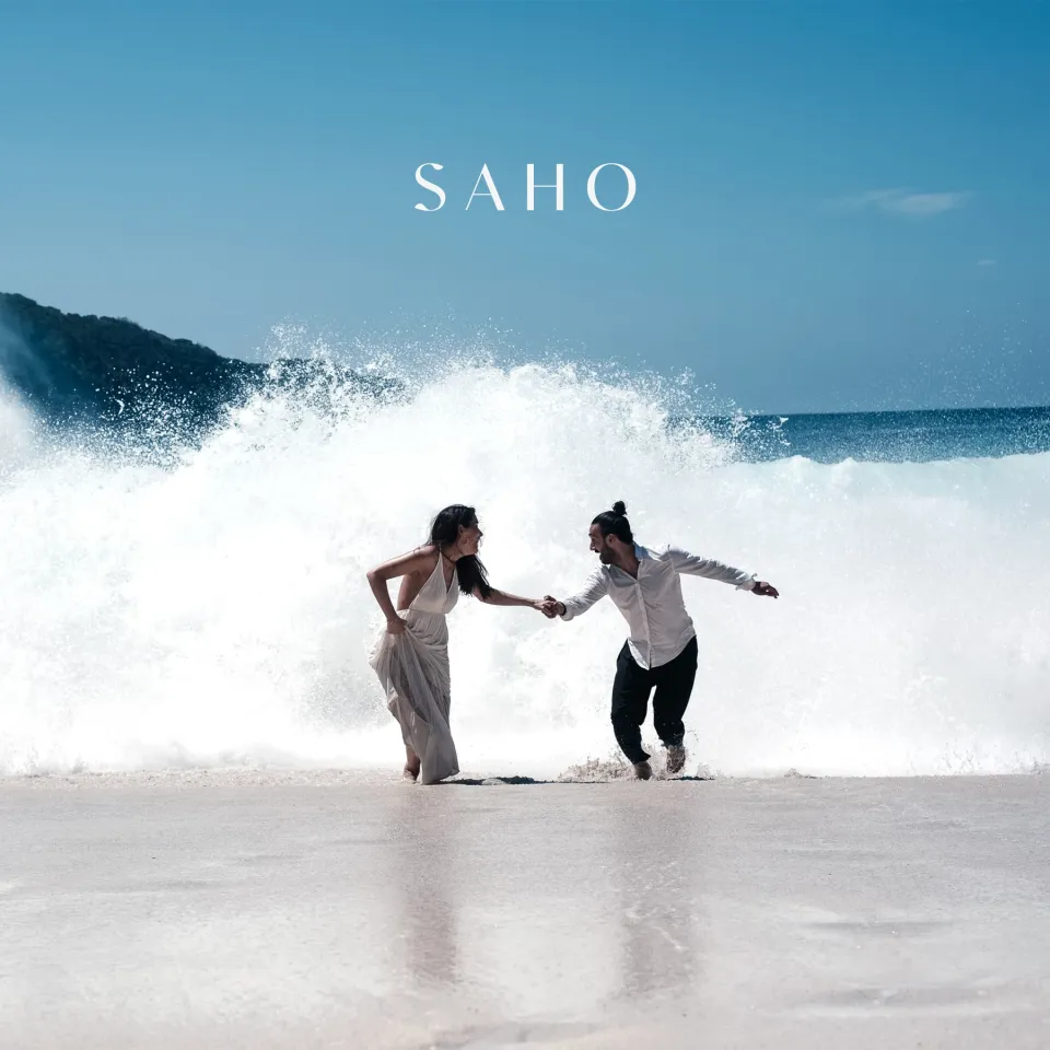 SAHO: Paar am Strand mit SAHO-Wortmarke